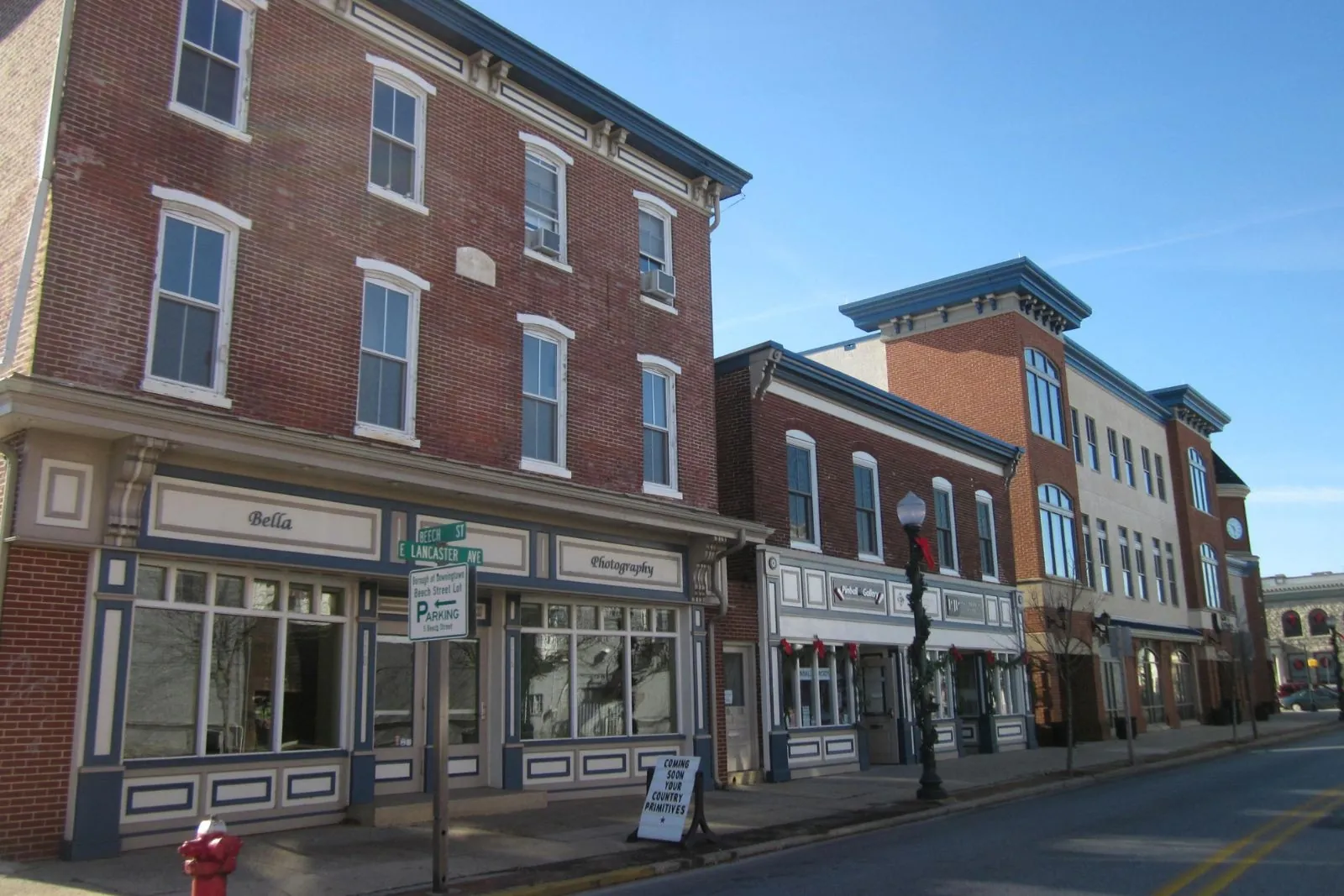 Three-story brick storefront buildings along a sunny street
