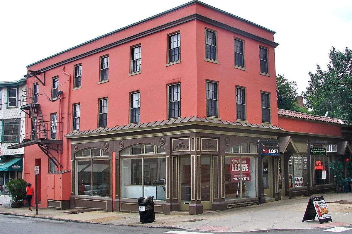 Red brick corner building with storefronts on a town street