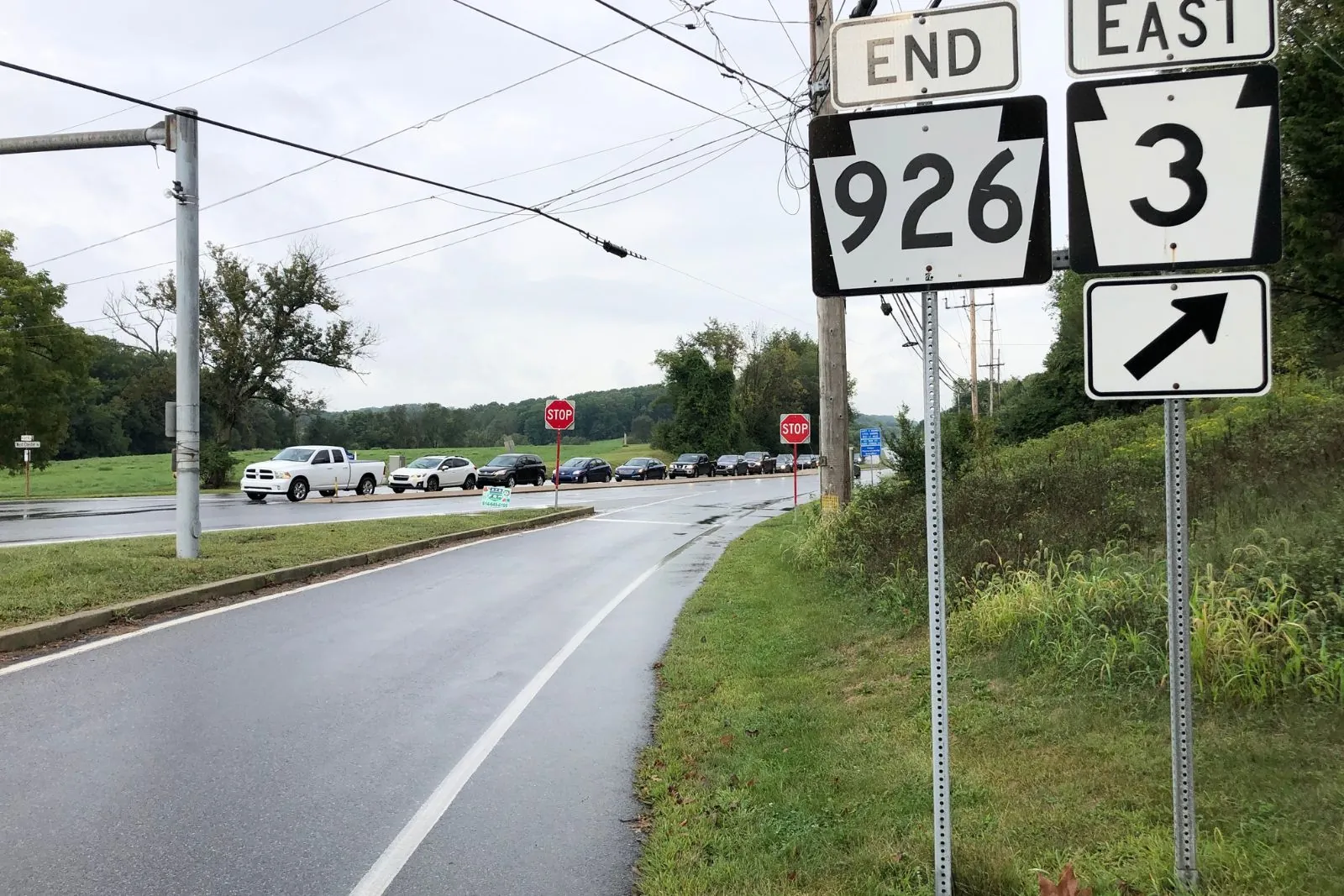 Route 926 end sign and Route 3 east sign beside a wet two-lane road